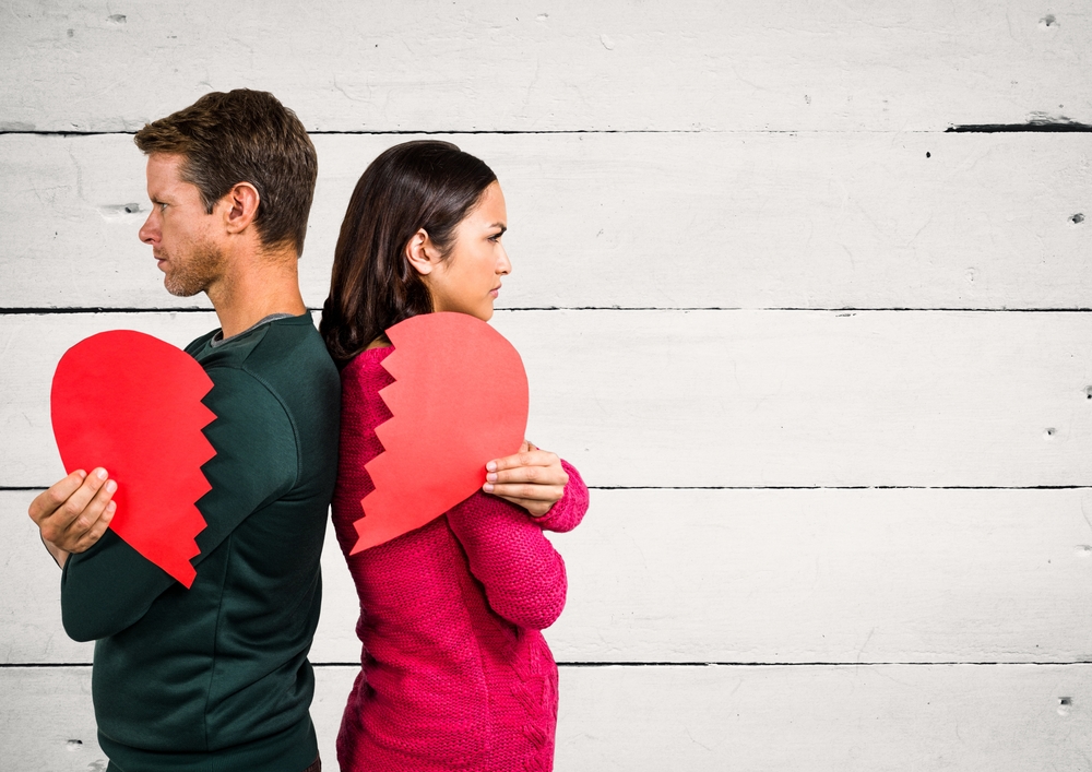 Angry,Couple,Holding,Broken,Heart,Against,Wooden,Background